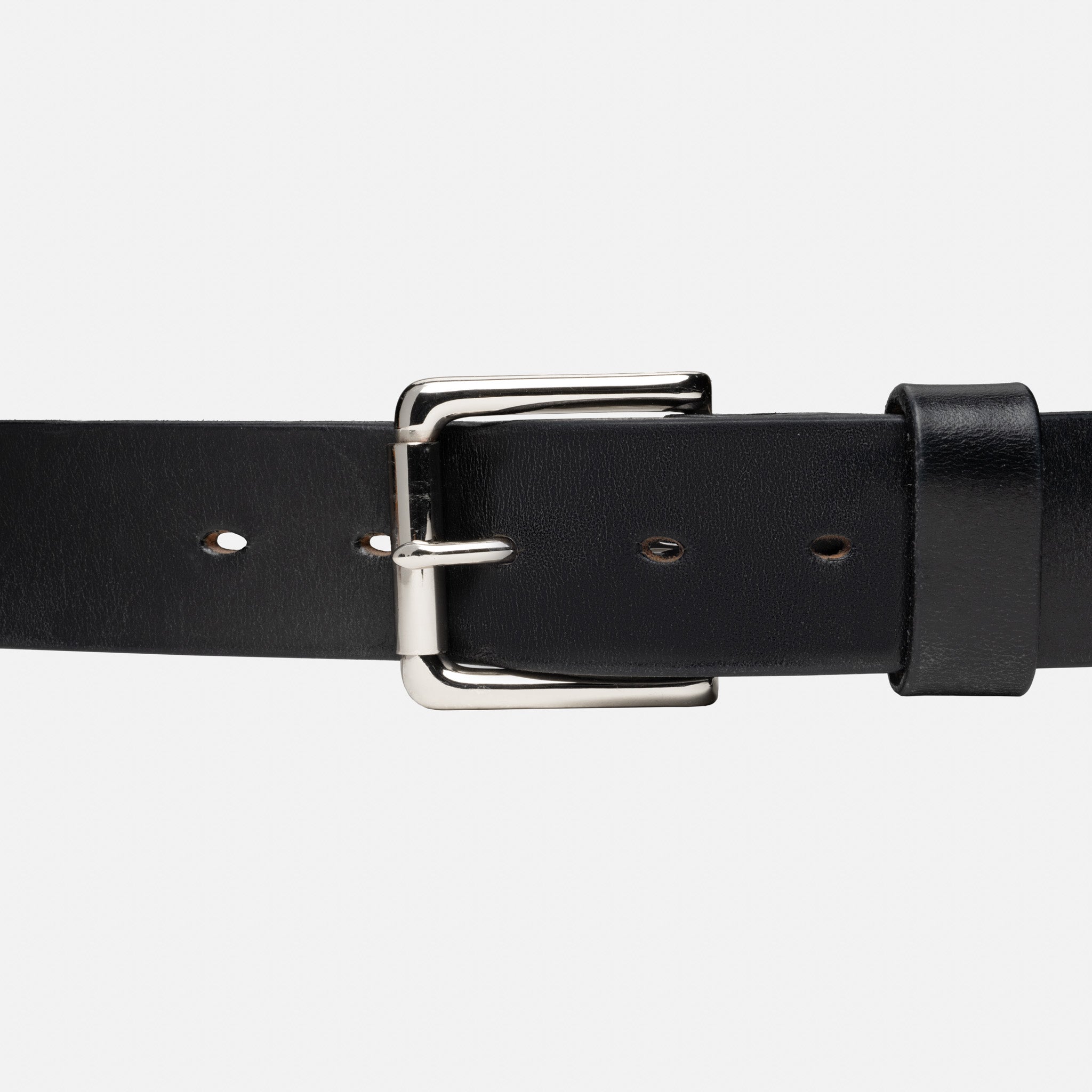 Black leather belt with a silver buckle on a light gray background
