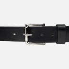 Black leather belt with a silver buckle on a light gray background